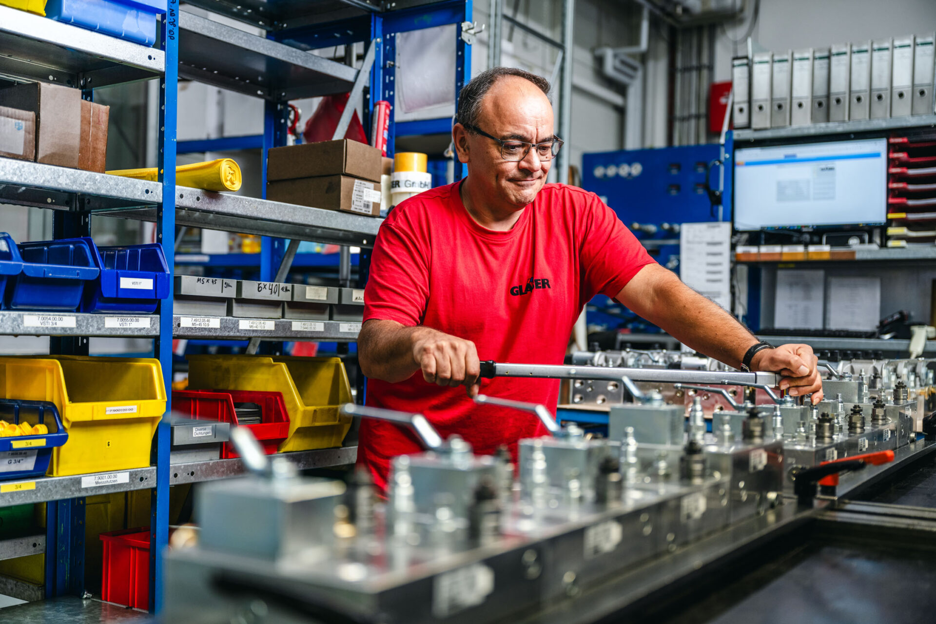 Viktor Lopez; Produktionsleiter der GLÄSER GmbH bei der Montage von Anbauteilen an Hydraulik-Steuerblöcken